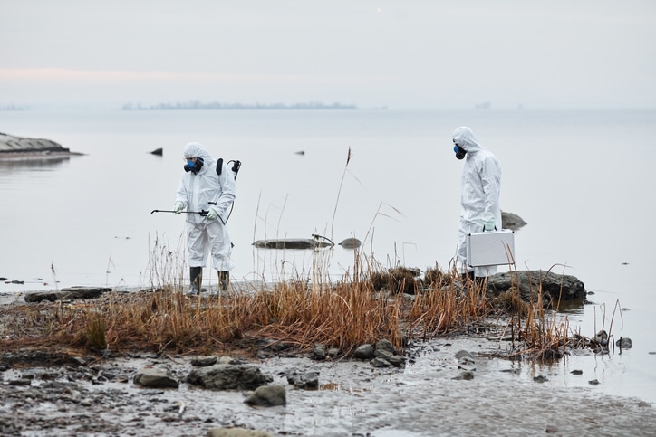 HAZAMT team wearing protective gear inspecting ecological disaster site,