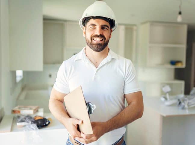 general contractor stood holding a case file and a safety helmet